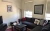 Lounge room with original artworks and red accents