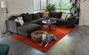 Living area with large couch, ceiling fan & aircon